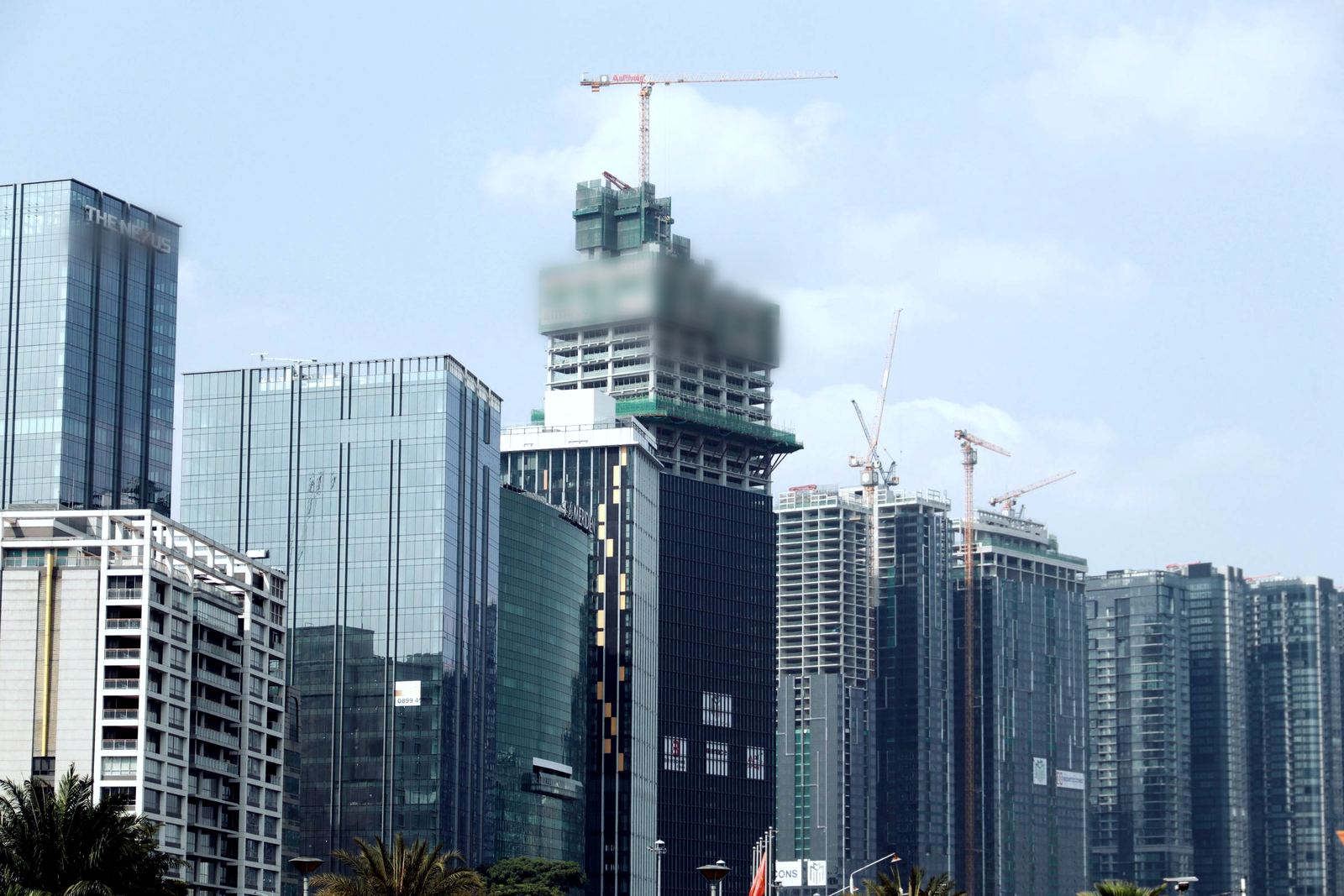 City skyline with tower cranes rising over buildings under construction